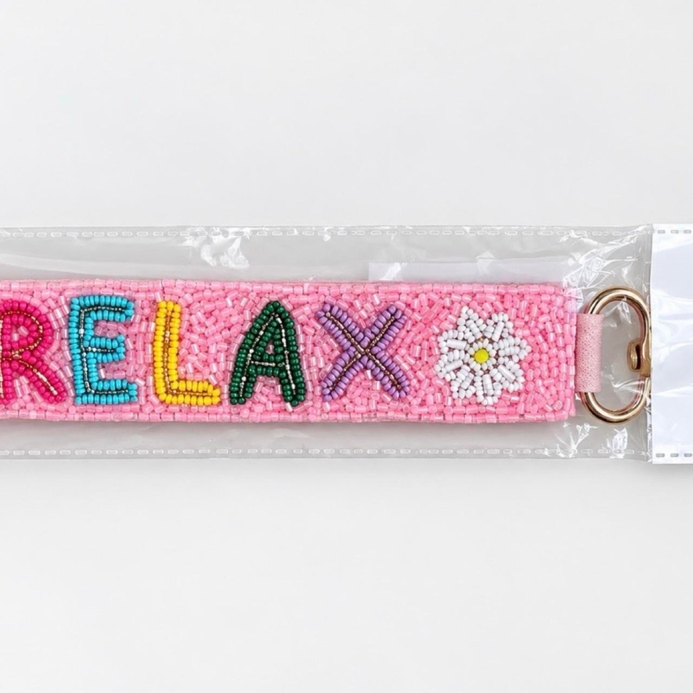 Pink beaded keychain with the word 'RELAX' and a white daisy